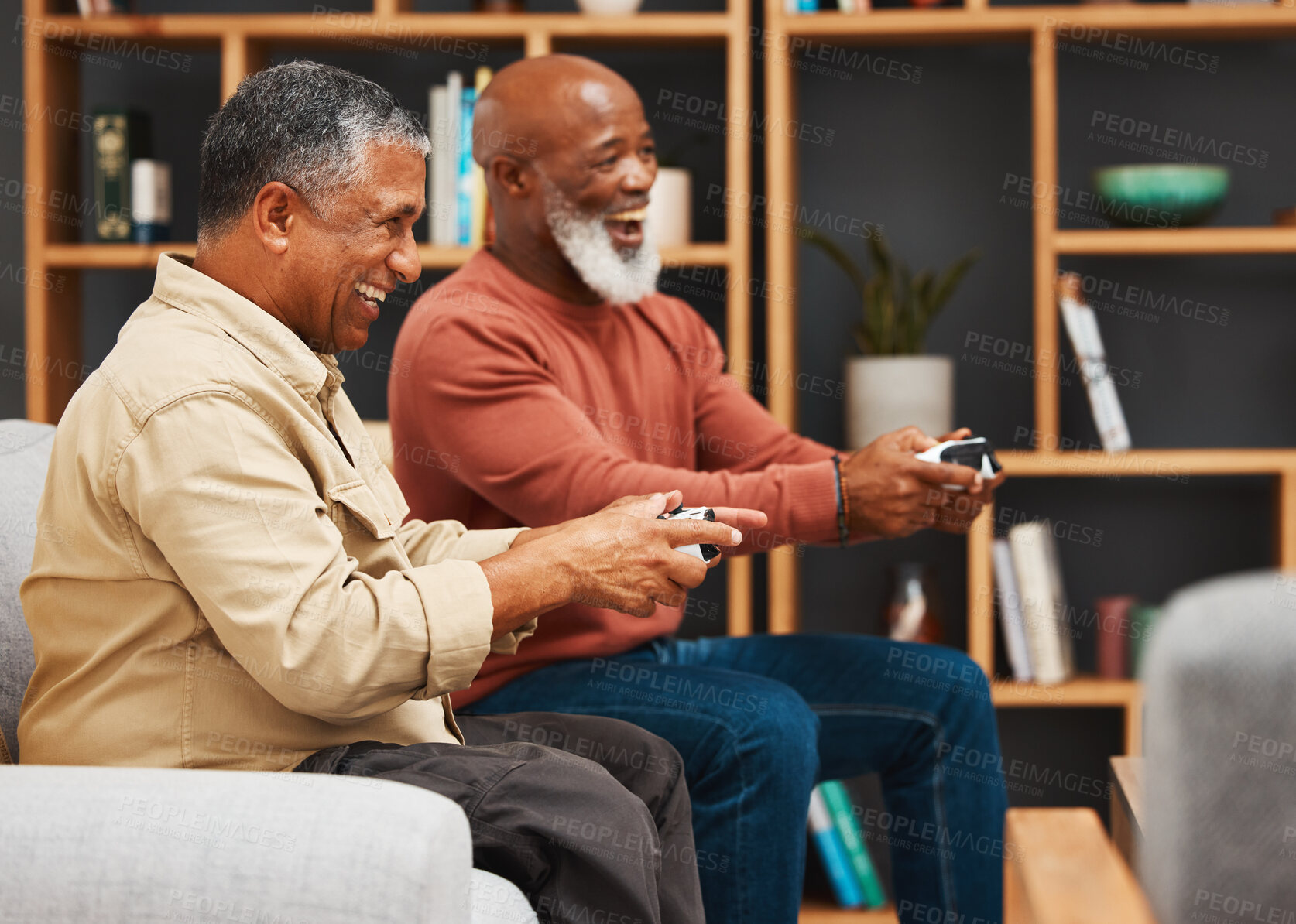 Buy stock photo Gaming, fun and senior black man friends playing a video game together in the living room of a home. Sofa, funny or retirement with a mature male gamer and friend enjoying a house visit to game