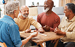 Senior men, friends and dominoes in board games on wooden table for activity, social bonding or gathering. Elderly group of domino players having fun playing and enjoying entertainment at home
