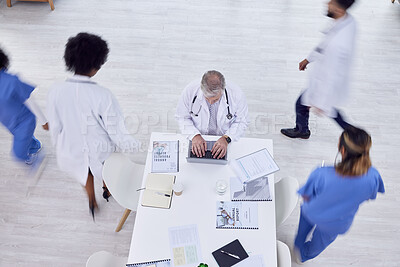 Buy stock photo Doctor, man and laptop in busy hospital for medicine research, surgery schedule management or medical life insurance. Top view, healthcare worker and surgeon on technology with motion blur coworkers