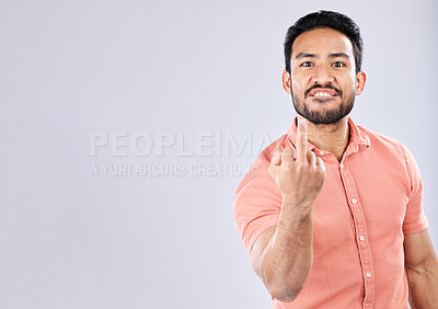 Buy stock photo Angry, rude and portrait of an Asian man with a middle finger isolated on a grey studio background. Mockup, space and Japanese guy with a mean, bad and negative hand gesture for anger and aggression