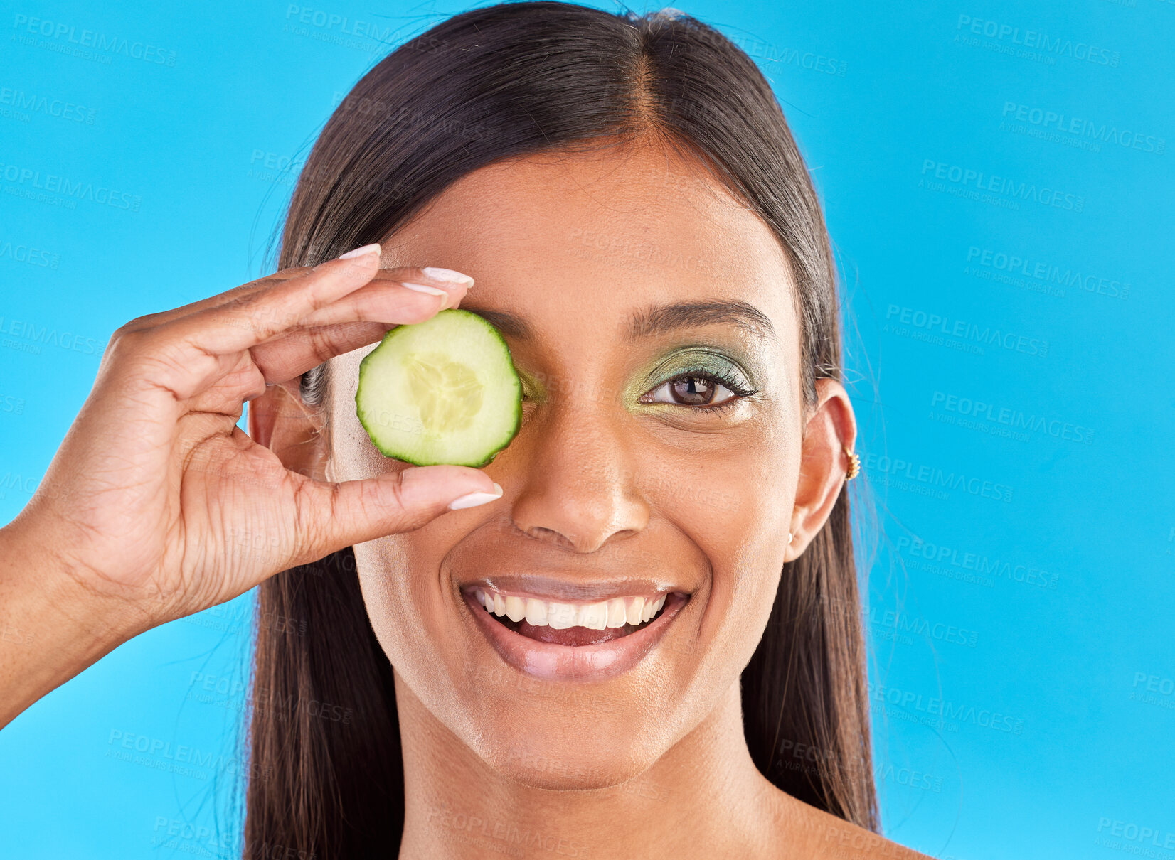 Buy stock photo Skincare, beauty and portrait of Indian woman with cucumber, makeup and facial detox with smile on blue background. Health, wellness and sustainability, organic luxury cleaning and grooming cosmetics