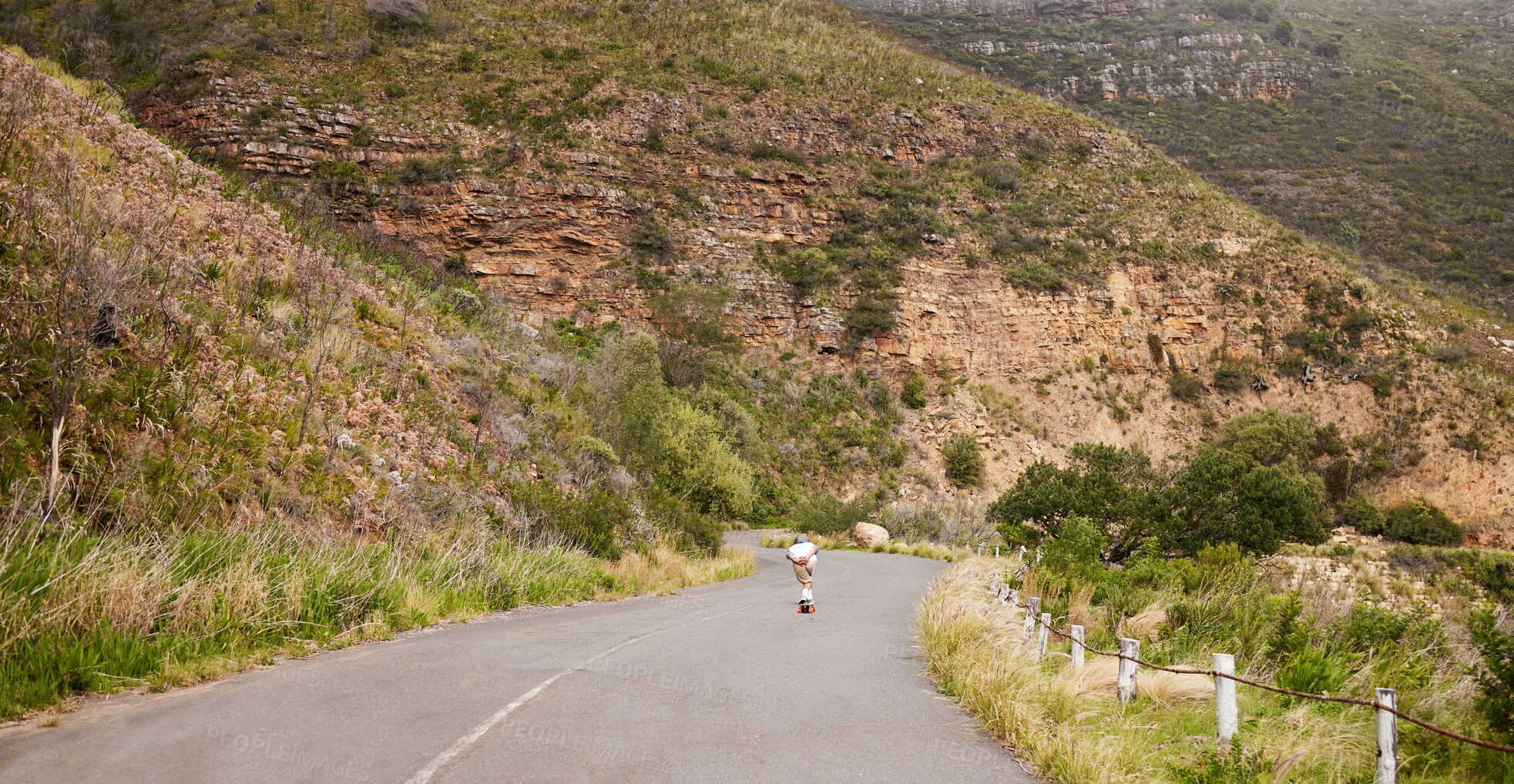 Buy stock photo Mountains, skateboard and sports with in road for training, speed and adventure. Freedom, youth and travel with guy skating fast  in urban street of nature for exercise, wellness and challenge  