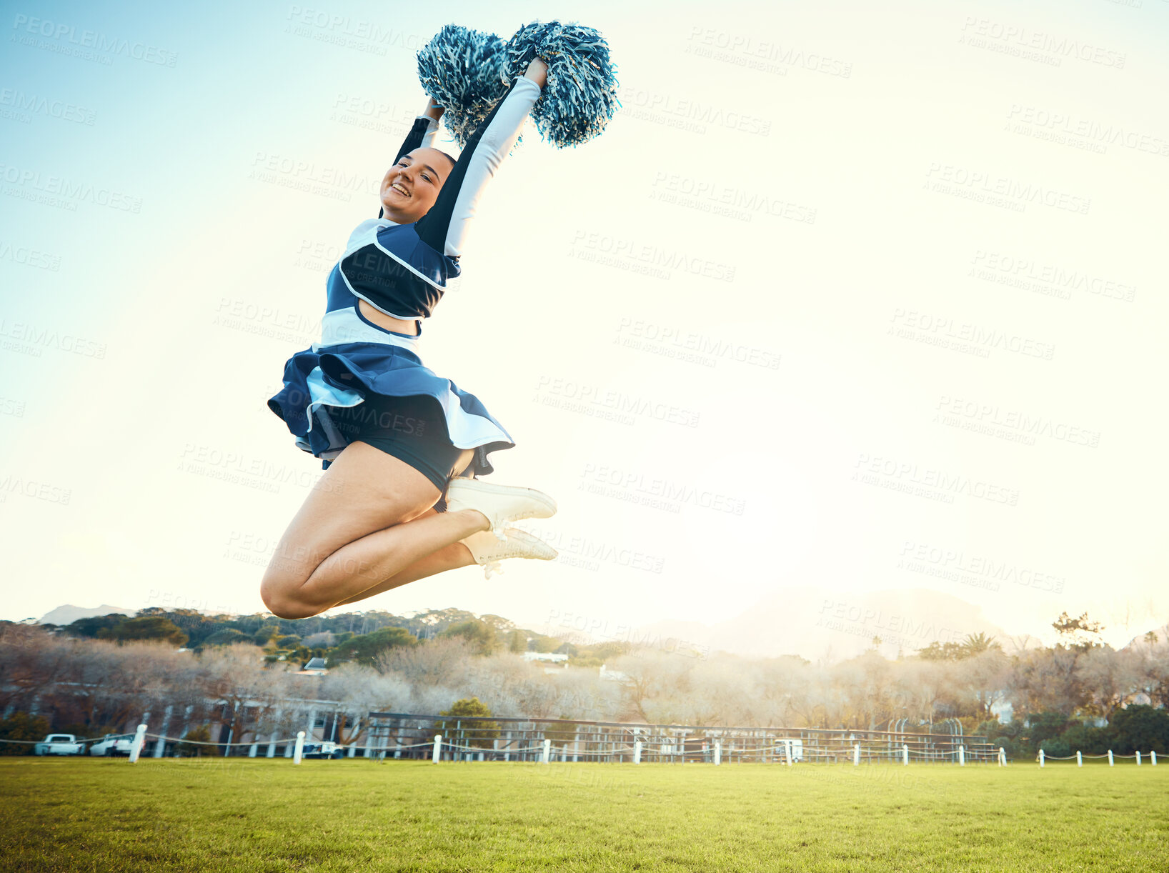 Buy stock photo Cheerleader, woman jump to sky for sports performance or celebration with energy outdoor. Cheerleading person dance in nature with space for training, exercise and sport competition to celebrate goal