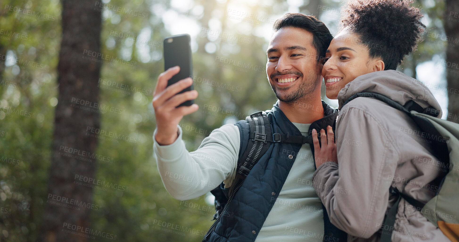 Buy stock photo Hiking, selfie and couple with hug, woods and adventure with wellness, breathing or vacation with freedom. People, man or woman embrace, profile picture or post with holiday, nature or weekend break