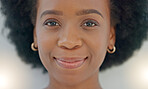 Portrait Young black woman smiling. Face of funky cheerful, gorgeous and edgy African American female or student with afro standing inside against grey background