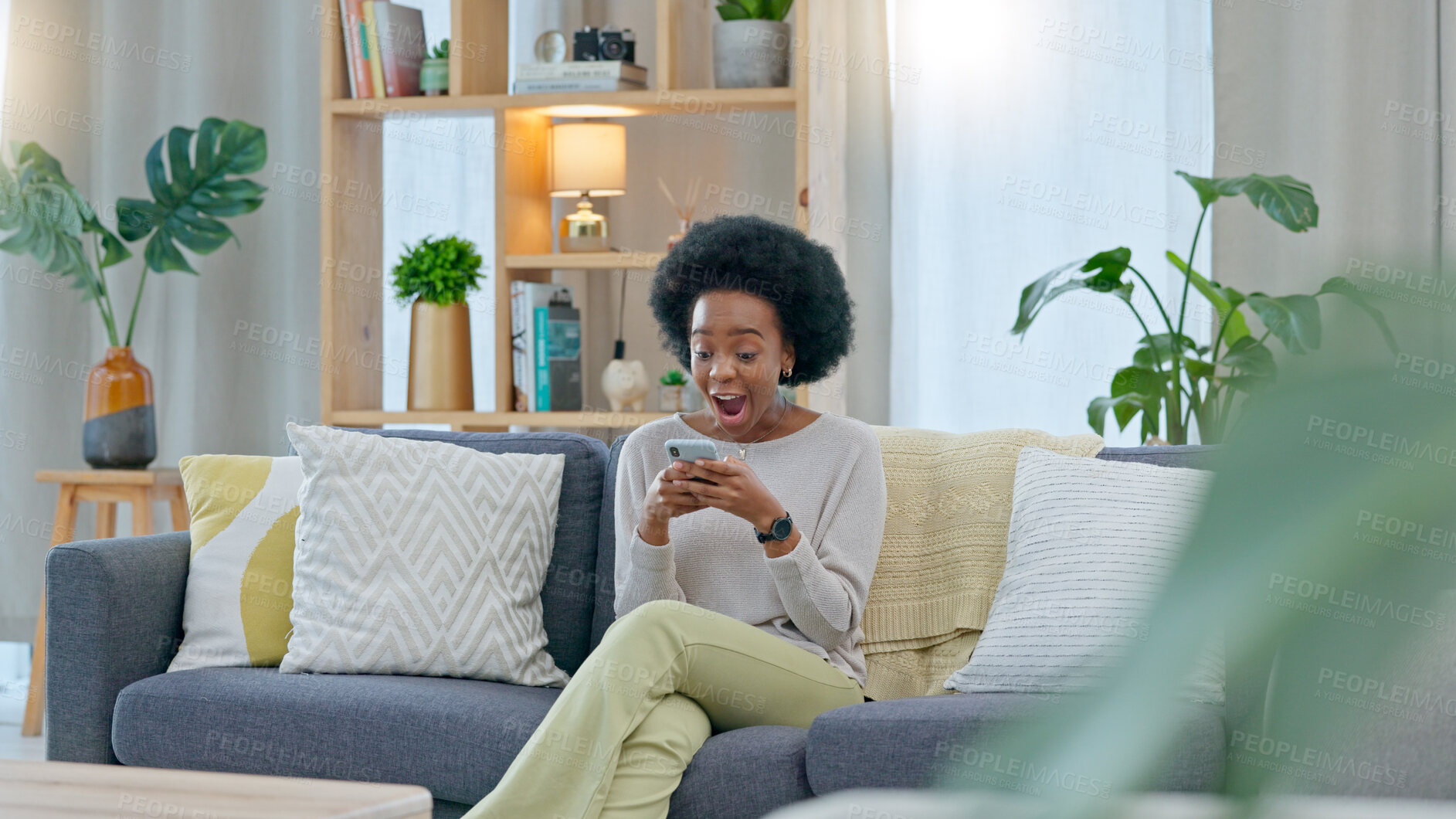 Buy stock photo Home, surprise and black woman with a smartphone, smile and email notification. with good news, prize and winning. African person, celebration or girl on a sofa, cellphone or winner with announcement