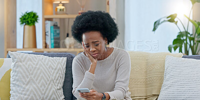 Sad woman crying after reading a breakup text message on her phone. Young female, upset after receiving bad news that has brought her to tears. Suffering from loss or having an emotional breakdown