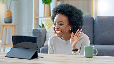 Young woman on a video call on her laptop sitting at home home using her wireless headphones. Cheerful and beautiful African American female with afro talking to her friend online with a chat app