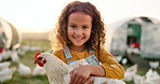 Chicken, smile and girl on a farm learning about agriculture in the countryside of Argentina. Happy, young and sustainable child with an animal, bird or rooster on a field in nature for farming