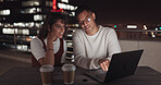 Laptop, collaboration and night with a business team working together on balcony in the city. Teamwork, computer and overtime with a man and woman employee at work late on a project deadline