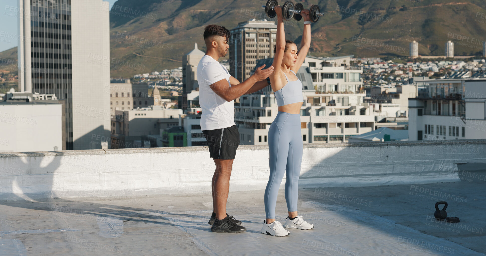 Buy stock photo Fitness, personal trainer and a woman outdoor with dumbbells for exercise, workout or training rooftop. Couple of friends in urban city for sports, strong muscle or bodybuilder and lifting weights