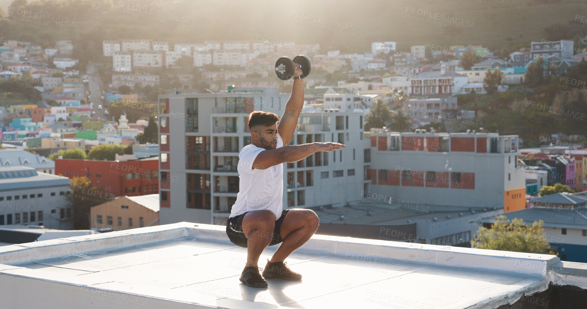 Buy stock photo Man, fitness and squat with dumbbell on rooftop in workout, training or outdoor exercise in city. Active male person, athlete or bodybuilder lifting weights on balcony for healthy body or wellness