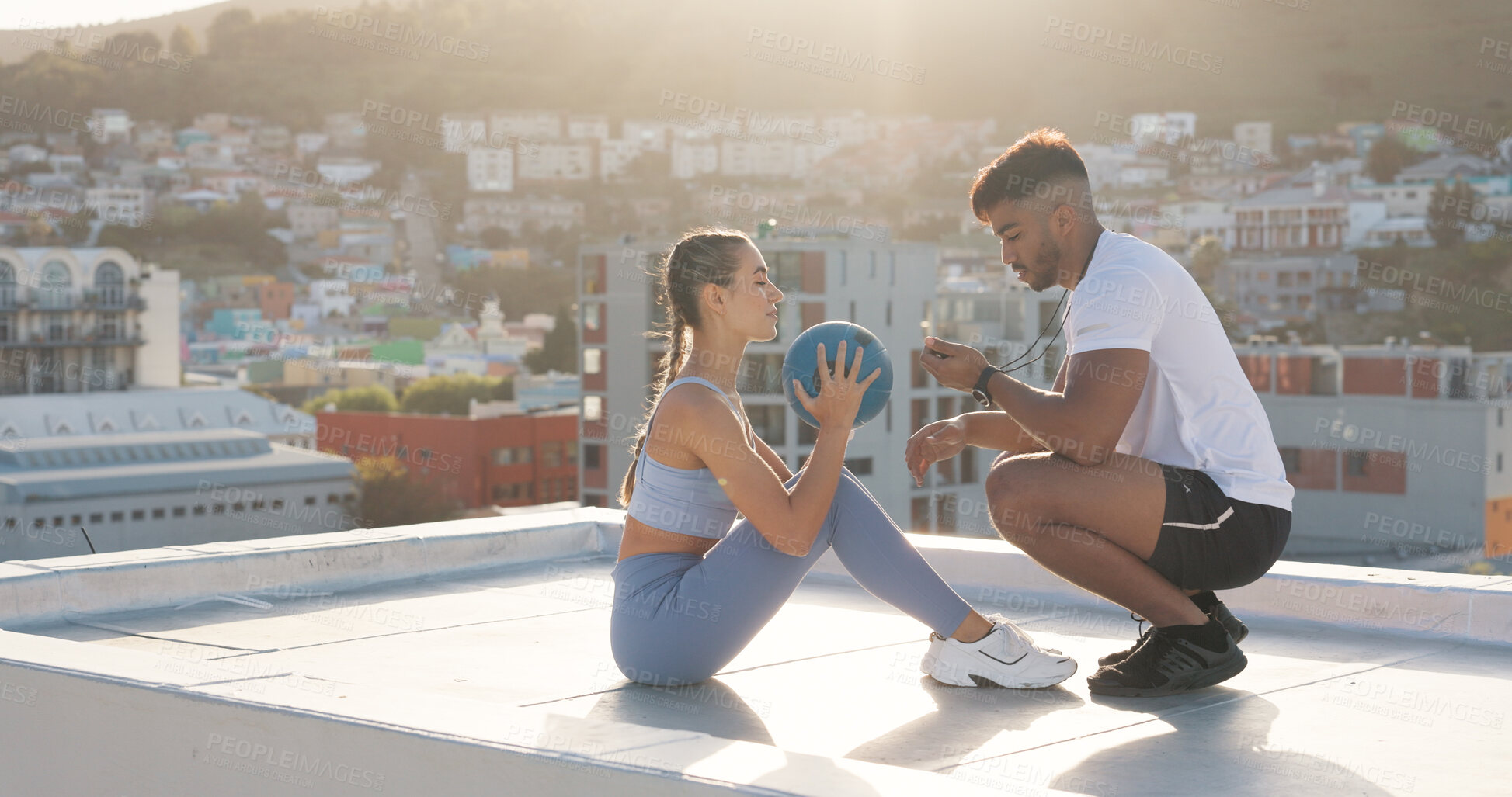 Buy stock photo Exercise, time and a personal trainer with a woman on rooftop outdoor for fitness, workout or training. Couple of friends in city with medicine ball, motivation and support for sit up challenge