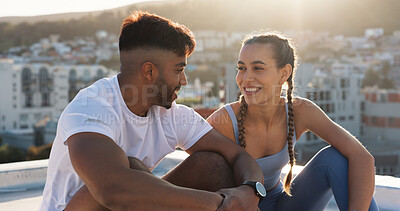 Buy stock photo Fitness, rest and couple outdoor for exercise, workout or training together on a city building rooftop. Happy man and woman on break with smile, communication or conversation for health and wellness