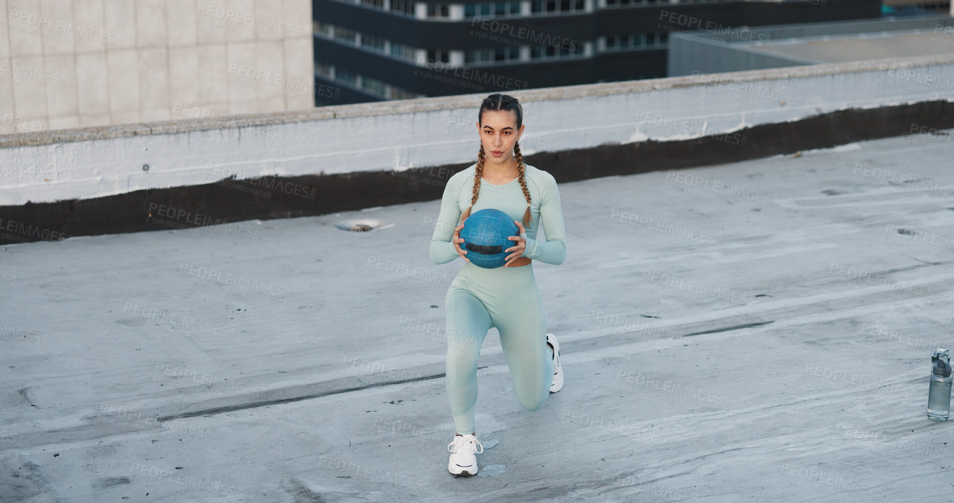 Buy stock photo Fitness, medicine ball and woman athlete in the city for a health, wellness and cardio workout or exercise. Equipment, sports and young female person training on building rooftop in urban town.