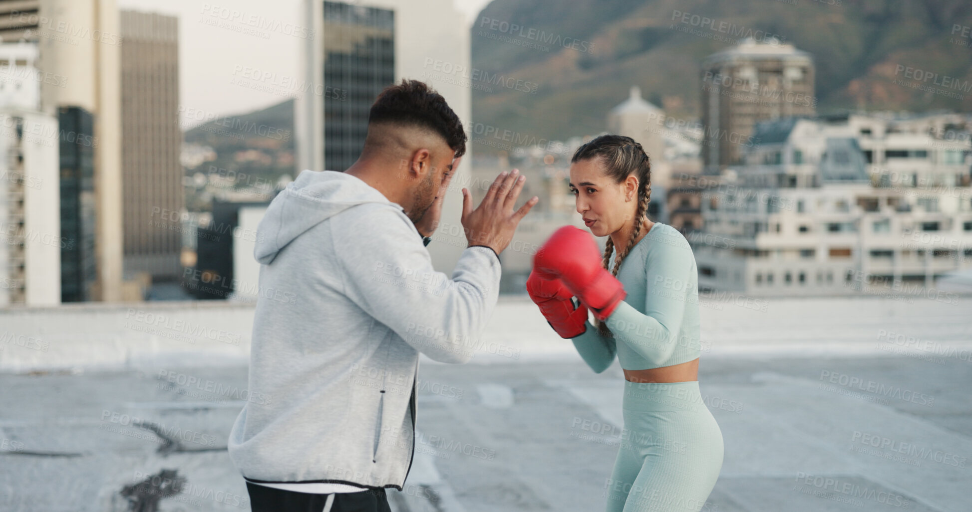 Buy stock photo Fitness, personal trainer and boxing training on rooftop in city for exercise, sport or outdoor workout. Woman boxer and man coaching in sports practice for fighting, cardio or self defense in town