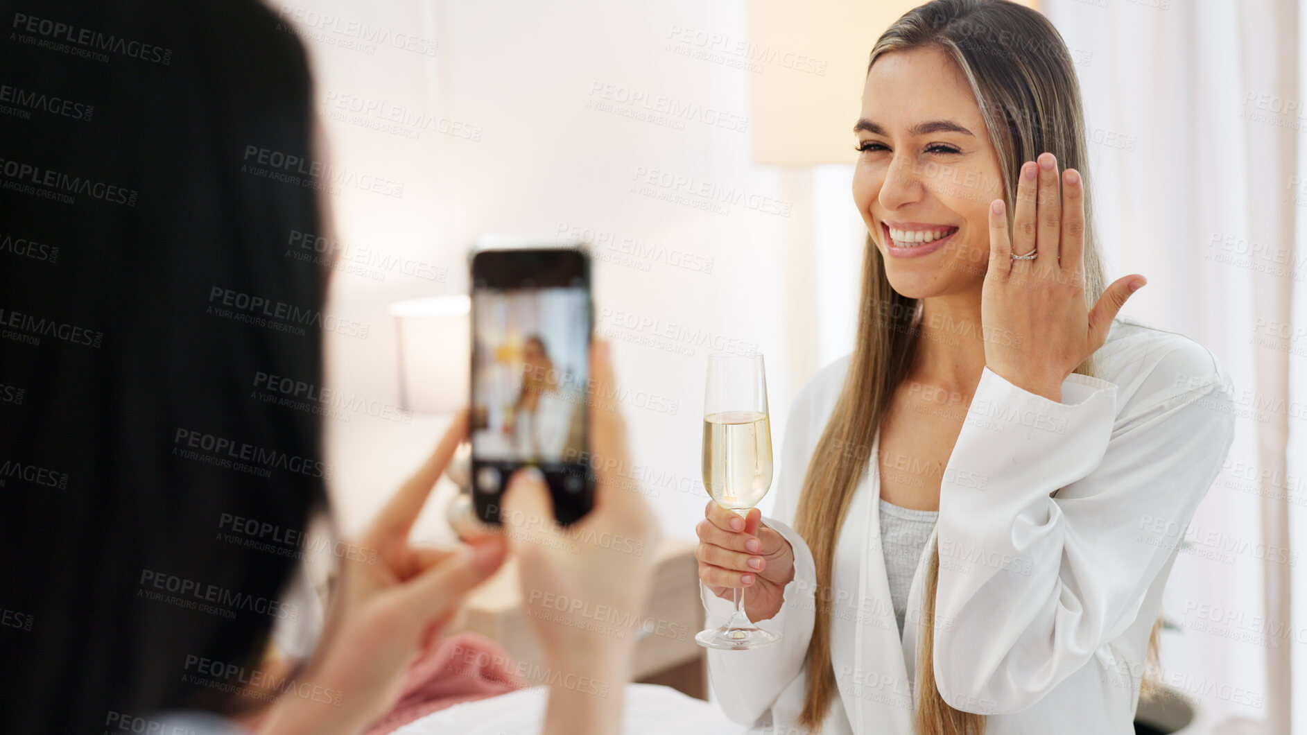 Buy stock photo Wedding ring, champagne and photograph of woman on phone, bride and friend. Engagement, wine glass and picture on mobile of person in celebration, happy memory and smile of bridesmaid on social media