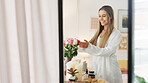 Smelling flowers, beautiful woman and beauty routine of a happy bride wearing a bathrobe while getting ready for her wedding day. Young female enjoying the aroma of fresh roses in her bedroom