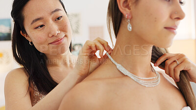 Wedding, jewelry and diamond with a bride and bridesmaid putting on a necklace before a marriage ceremony or celebration event. Happy, love and tradition with a woman and her friend getting ready