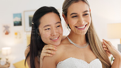 Wedding, bride and bridesmaid looking happy, proud and excited share hug, joy and love wearing white dress and ready for ceremony. Interacial asian woman and friend laughing waiting for a celebration