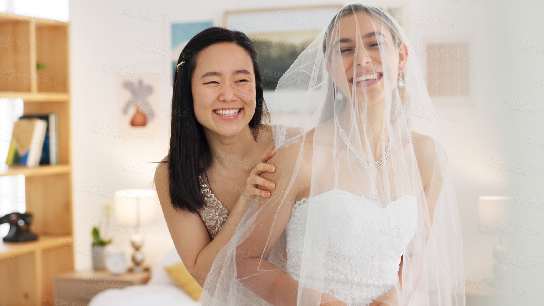 Buy stock photo Bride, wedding day and maid of honor woman or friends getting dressed for event and marriage. Bridesmaid helping person with a veil and dress while happy and laughing together in room before ceremony