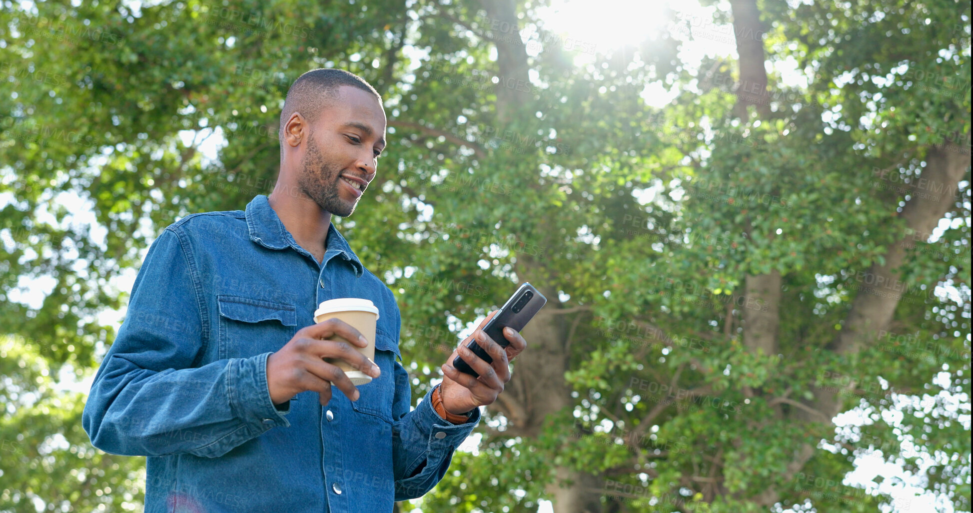 Buy stock photo Phone, park and black man relax with coffee, happy and calm in nature for travel, communication and sunshine. Tea, person and online chat while standing in forest with smile and carefree on weekend