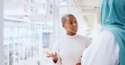 Teamwork, business people and leadership of black woman with sticky note in office workplace. Coaching, collaboration and female employees brainstorming sales or marketing strategy on glass wall.