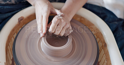 Pottery, art and hands on a potter wheel with artist spinning clay in creative class, workshop or studio. Creativity, handicraft and closeup of a sculptor working on ceramic design, craft or creation