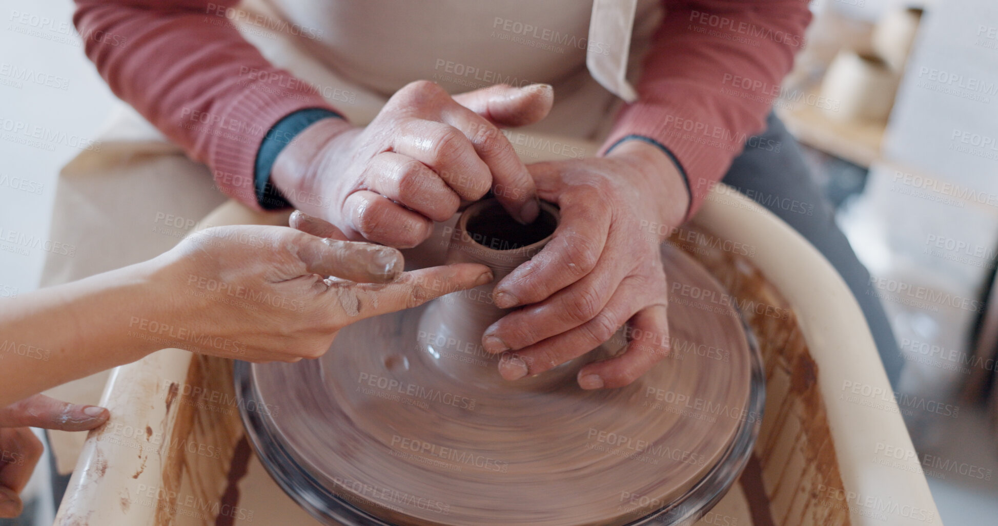 Buy stock photo Pottery, hands and clay on wheel together, help with container or bowl in studio, workshop or class. Artist, teacher and student with creative, unique mold or shape for ceramic product design process