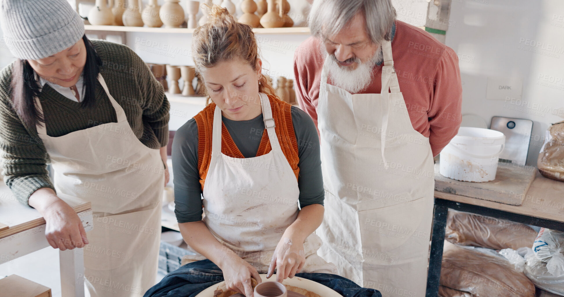 Buy stock photo Pottery, teacher and senior couple in workshop for learning, hobby and skill together. Creative studio, art instructor and people with woman for lesson to mold clay to craft ceramic mug, cup or bowl
