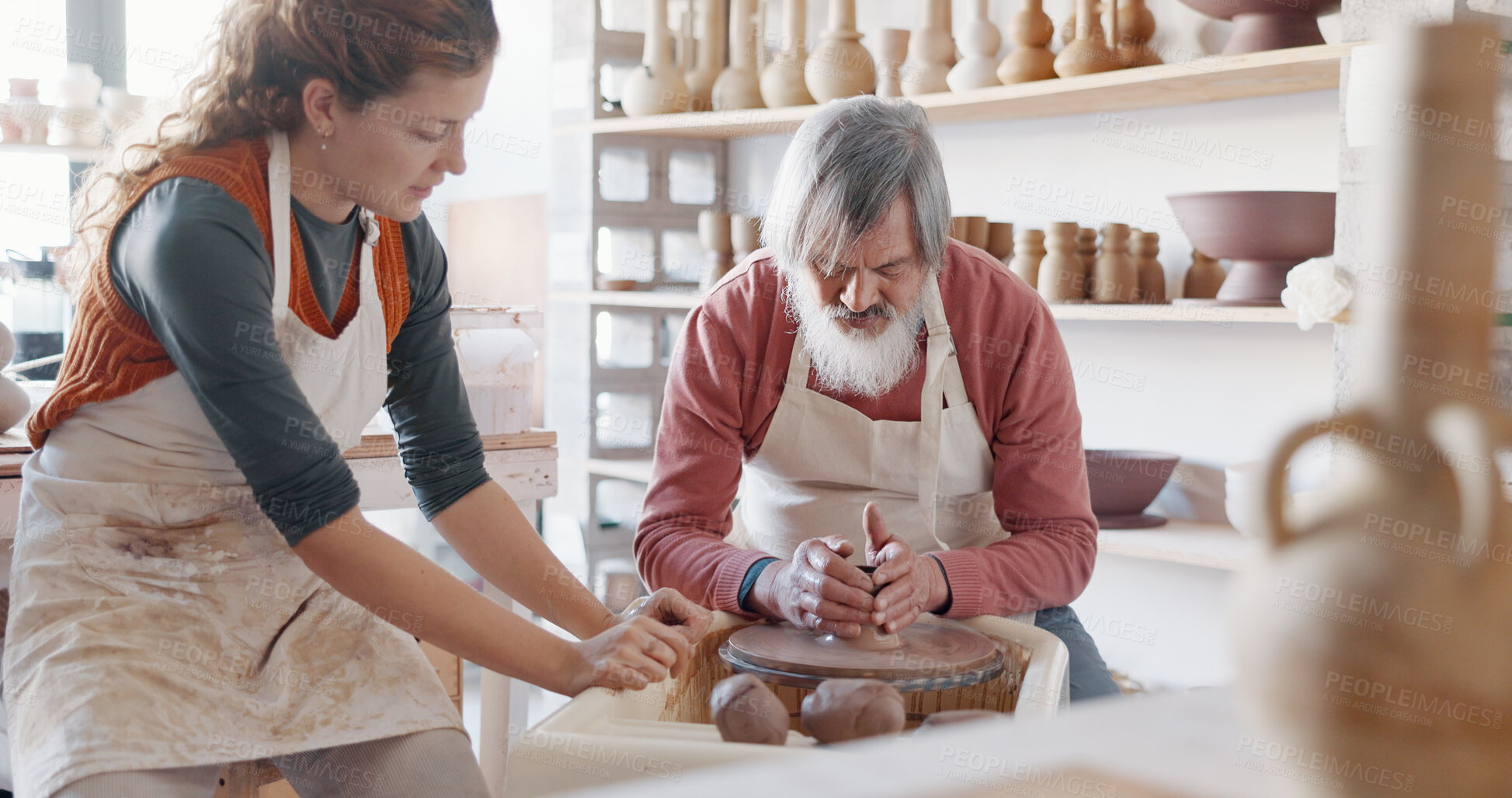 Buy stock photo Pottery, wheel and teacher with student in workshop for art learning with clay sculpting or molding. Creative, teaching and artist manufacturing a mud ceramic design product with mentor in a studio.