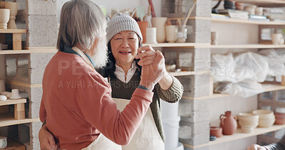 Pottery, creative and senior couple talking about art dancing together in a studio class. Elderly Asian man and woman hugging with love while learning and working with clay on a date