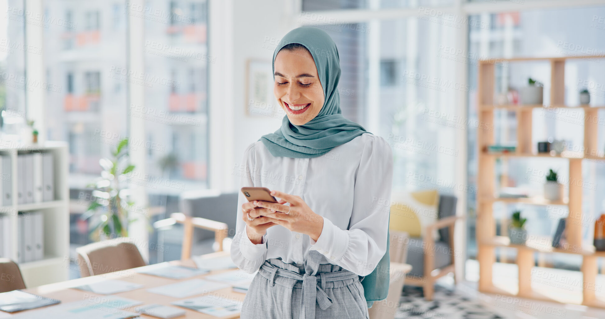 Buy stock photo Muslim, phone or happy woman on social media for communication or texting in startup office. Funny meme, smile or Islamic employee in online conversation on mobile app to scroll on internet website