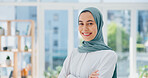 Face, mindset and vision with a business muslim woman standing arms crossed in her office at work. Portrait, confidence and empowerment with an islamic female employee working on company growthFace, mindset and vision with a business muslim woman standing