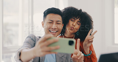 Phone, selfie and business people with peace in office for teamwork, collaboration and friendly workspace. Success, diversity and Asian man and black woman with smartphone, peace sign and smile