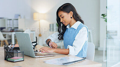 Young business woman resting after finally meeting a deadline working on a laptop alone at work. Pleased black female corporate professional taking a break and checking the time while sending emails