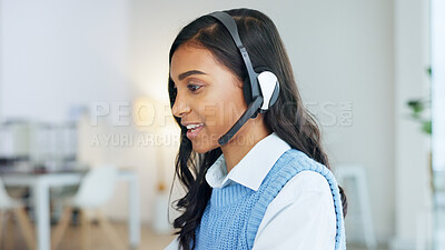Friendly call center agent using a headset while consulting for customer service and sales support. Confident and happy young business woman smiling while operating a helpdesk and talking to clients