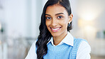 Portrait of a young designer smiling while working on a laptop in a modern office. Confident and happy indian business woman feeling ambitious and motivated for success in a creative startup agency