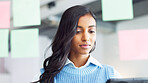 Young business woman brainstorming and planning a mind map with ideas on sticky notes on a glass wall in an office. One focused designer thinking while analyzing a marketing strategy with solutions