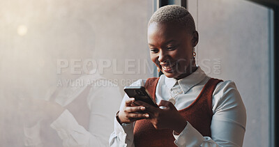 Happy, smile and face of a black woman on a phone while standing by the window in office. Technology, happiness and African female employee networking on social media or the internet on break at work
