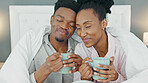 Coffee, bed and couple with a man and woman in the bedroom to relax in their home together. Drink, tea and romance with a young male and female sitting in their house in the morning over a weekend