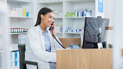 Pharmacist woman answering the telephone and giving advice to customer on flu shot treatment options in pharmacy. Chemist assisting remote client by checking medicine stock on their computer database