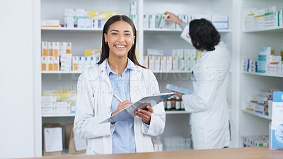 Portrait of a cheerful and friendly pharmacist using a digital tablet to check inventory or online orders in a chemist. Young latino woman using pharma app to do research on medication in a pharmacy