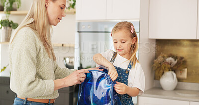 Backpack, kitchen and mother with child for school lunchbox, sandwich and healthy food for nutrition, wellness and development. Helping, support and care of a mom with her kid bag for back to school