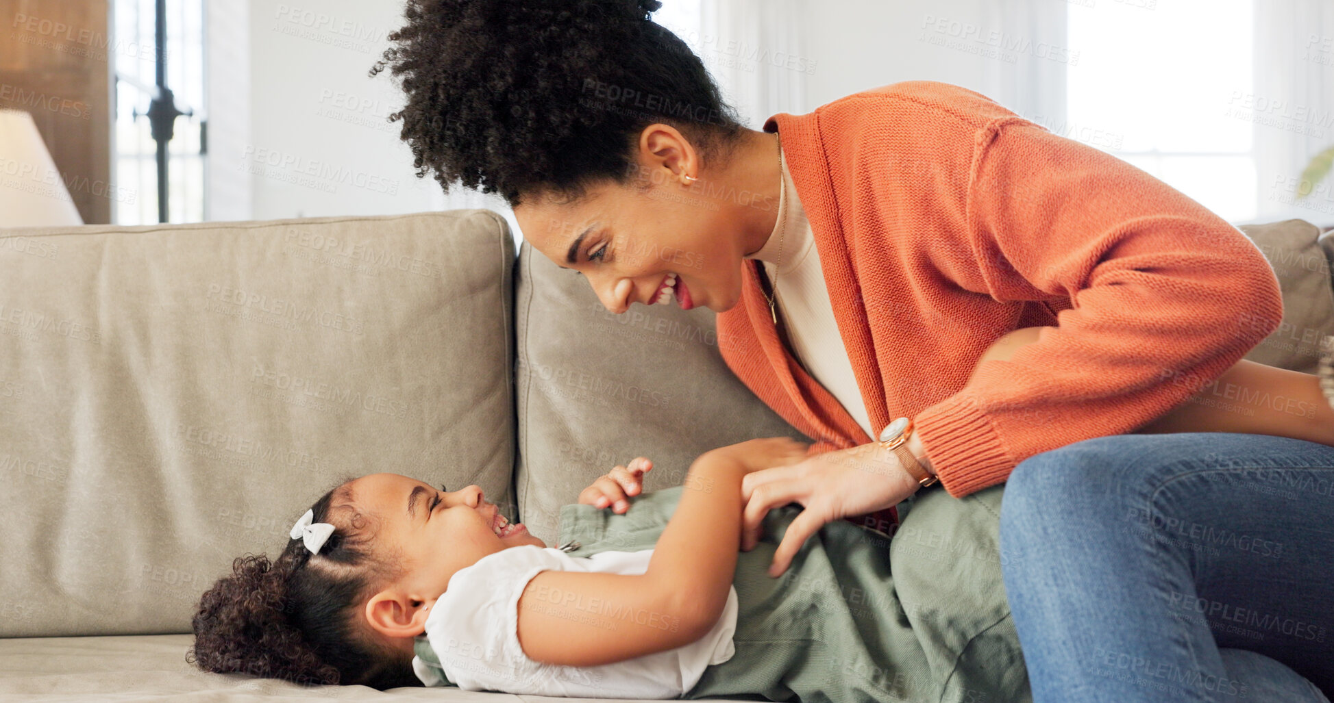 Buy stock photo Mom, girl child and tickling on sofa, care and love with funny game, excited and bonding in family home. Comic laugh, mother and daughter with playful memory, relax and lounge couch in living room