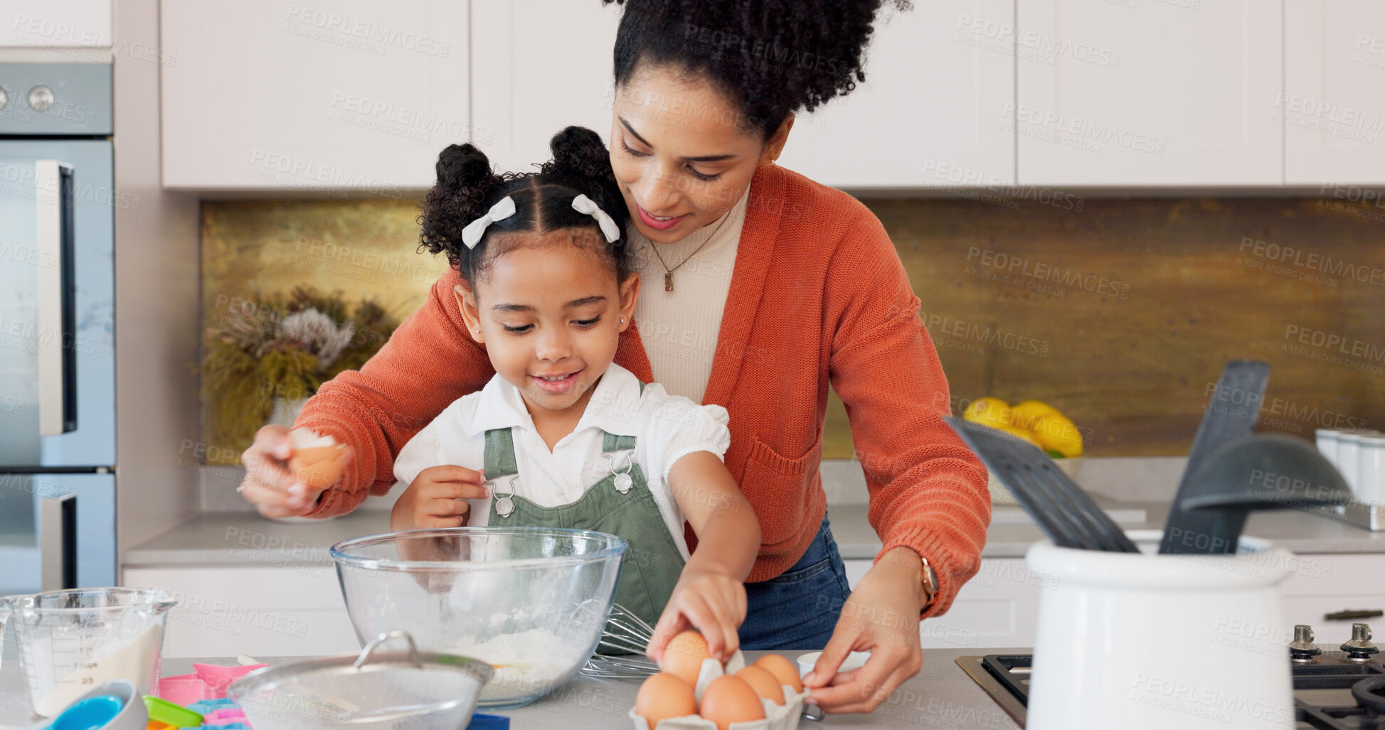 Buy stock photo Baking, kitchen and mother and kid with eggs learning, helping and bonding for dessert recipe. Happy family, African parents and mom teaching girl to bake with flour, ingredients and cake in home