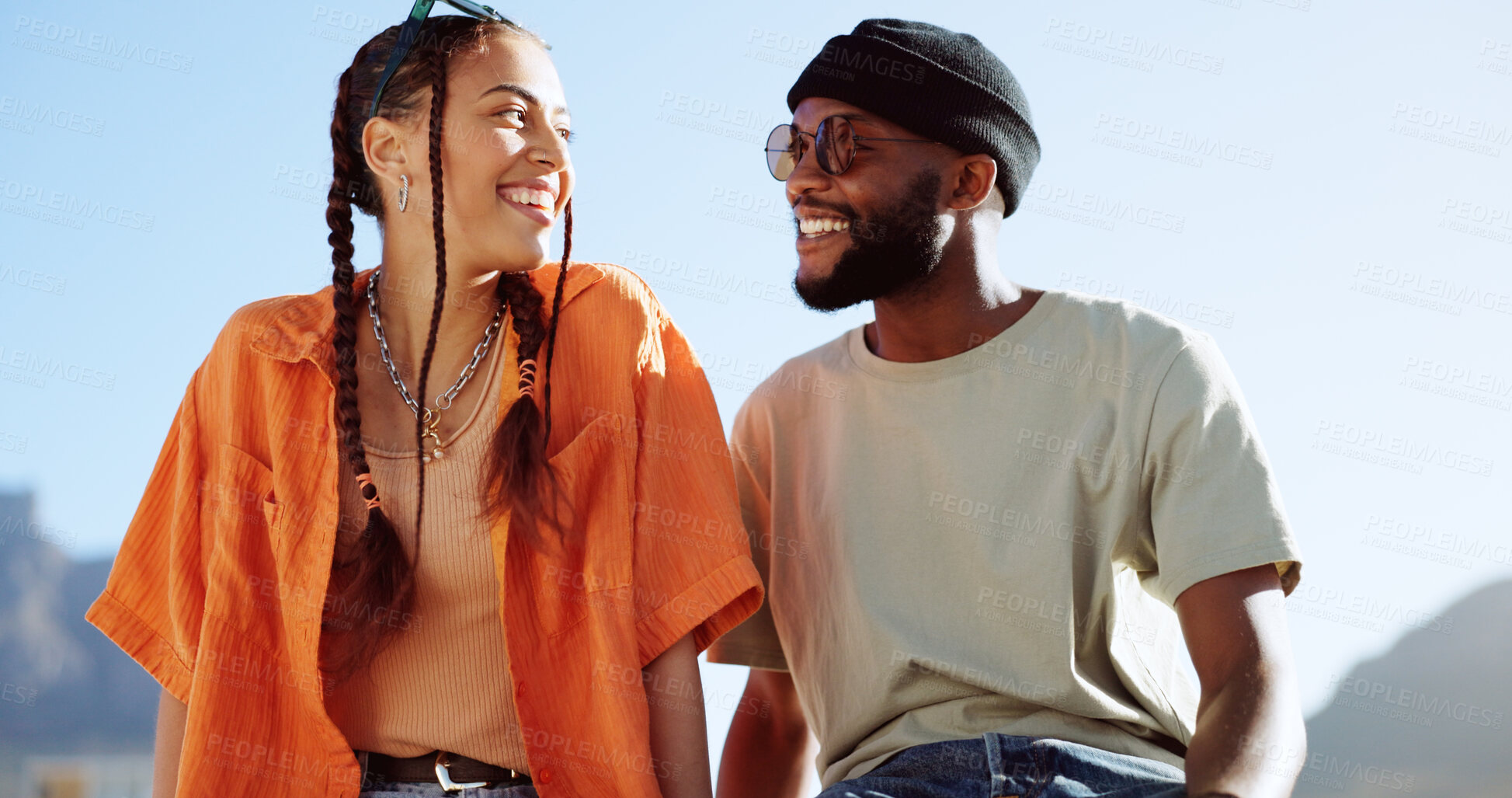 Buy stock photo Couple of friends, rooftop and smile in city, relax and youth in happy social bonding with summer sky. Diversity, gen z man and woman sit on roof with fashion, love and  cool urban date together.