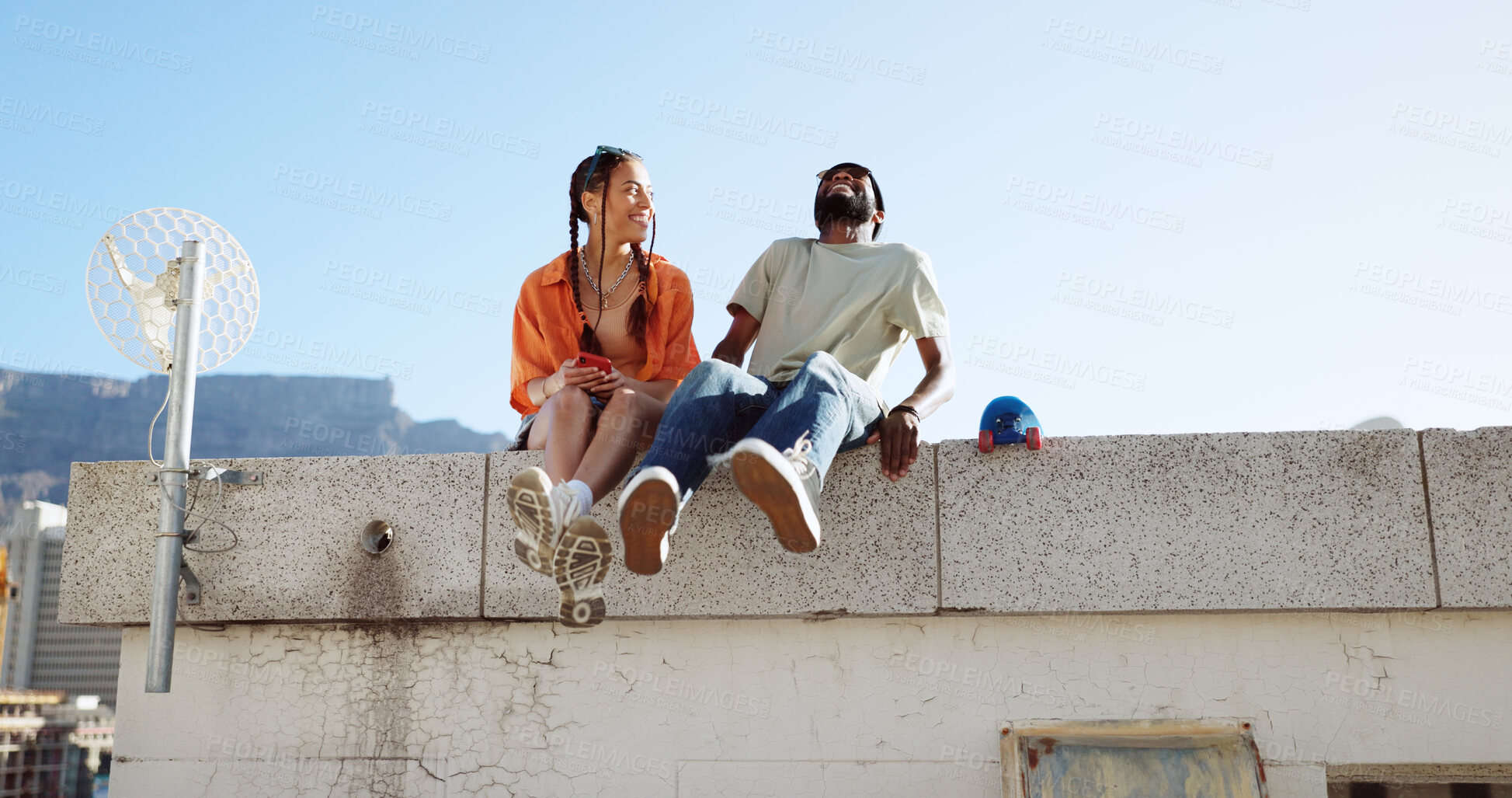 Buy stock photo Couple of friends, roof and laughing on city building, fun and youth in happy social bonding on summer sky. Joke, gen z man and woman on rooftop with smile, comedy and relax on urban date together.