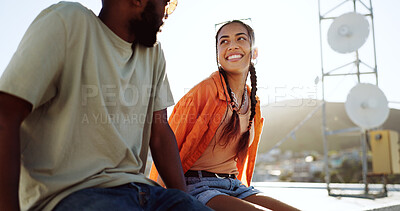 Buy stock photo Happy woman, man and rooftop date on city building, talking and youth bonding with freedom. Diversity, gen z couple of friends sitting on roof with smile, love and relax on urban social together.