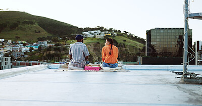 Couple, city rooftop and relax together with love, friendship and romance during a sunset picnic. Urban friends, freedom and peace talking on lunch date in Cape Town South Africa cityscape background